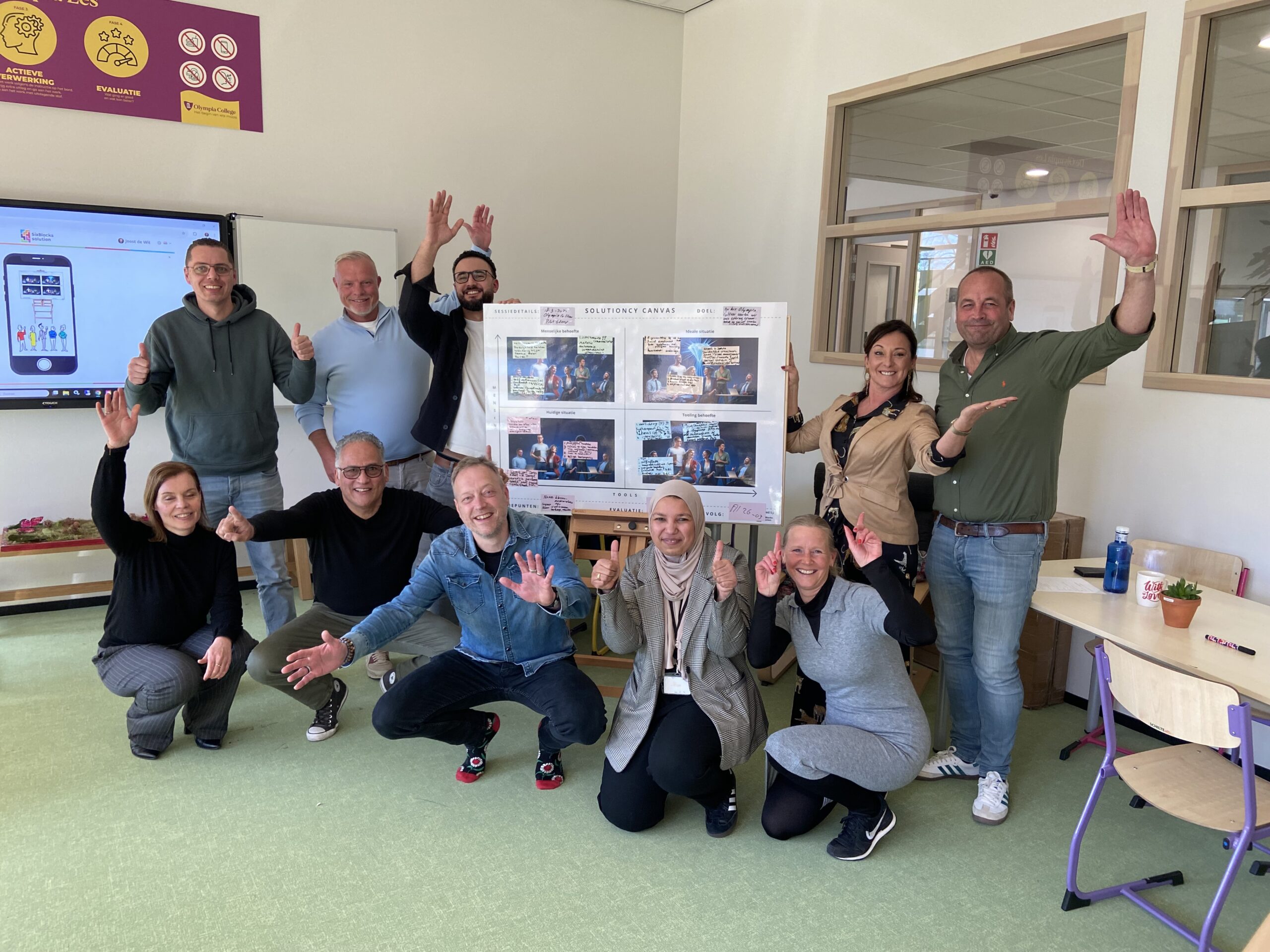 Team Olympia College Professioneel team werkt samen aan een business case met behulp van het Solutioncy Platform op een computer, in een kantooromgeving met de Solutioncy Canvas zichtbaar op de achtergrond.